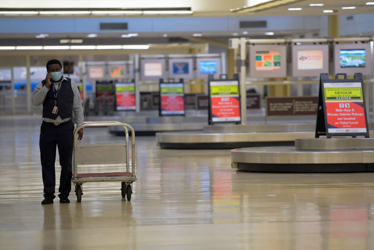 An American Airlines worker walks among a deserted baggage claim area at Reagan National Airport in Arlington, Virginia, on April 30, 2020.