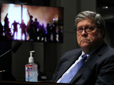 Attorney General William Barr watches a Republican Exhibit video during a House Judiciary Committee hearing, July 28, 2020, in Washington, D.C.