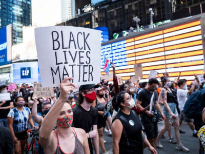 A protester holds a sign reading "BLACK LIVES MATTER" during a march