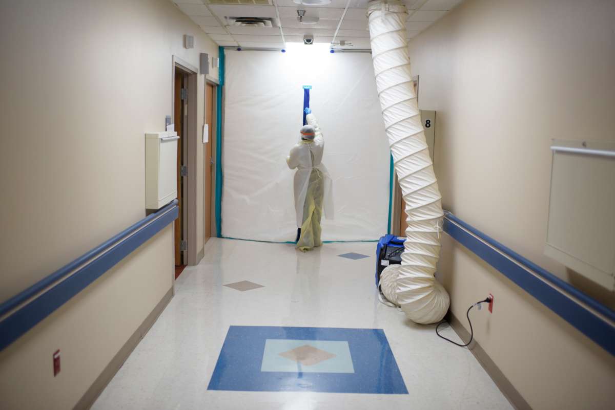 A healthcare worker zips up a protective barrier in the COVID-19 Unit at United Memorial Medical Center in Houston, Texas, on July 2, 2020.