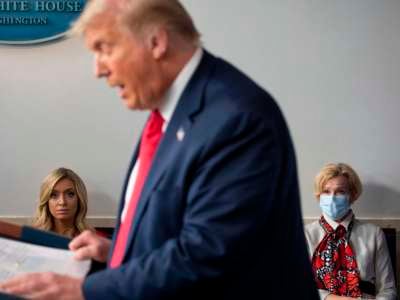 White House Press Secretary Kayleigh McEnany (left), not wearing a facemask, sits next to Response coordinator for White House Coronavirus Task Force Deborah Birx, wearing a facemask, as they listen to Donald Trump deliver a news conference in the Brady Briefing Room of the White House in Washington, D.C., on July 23, 2020.