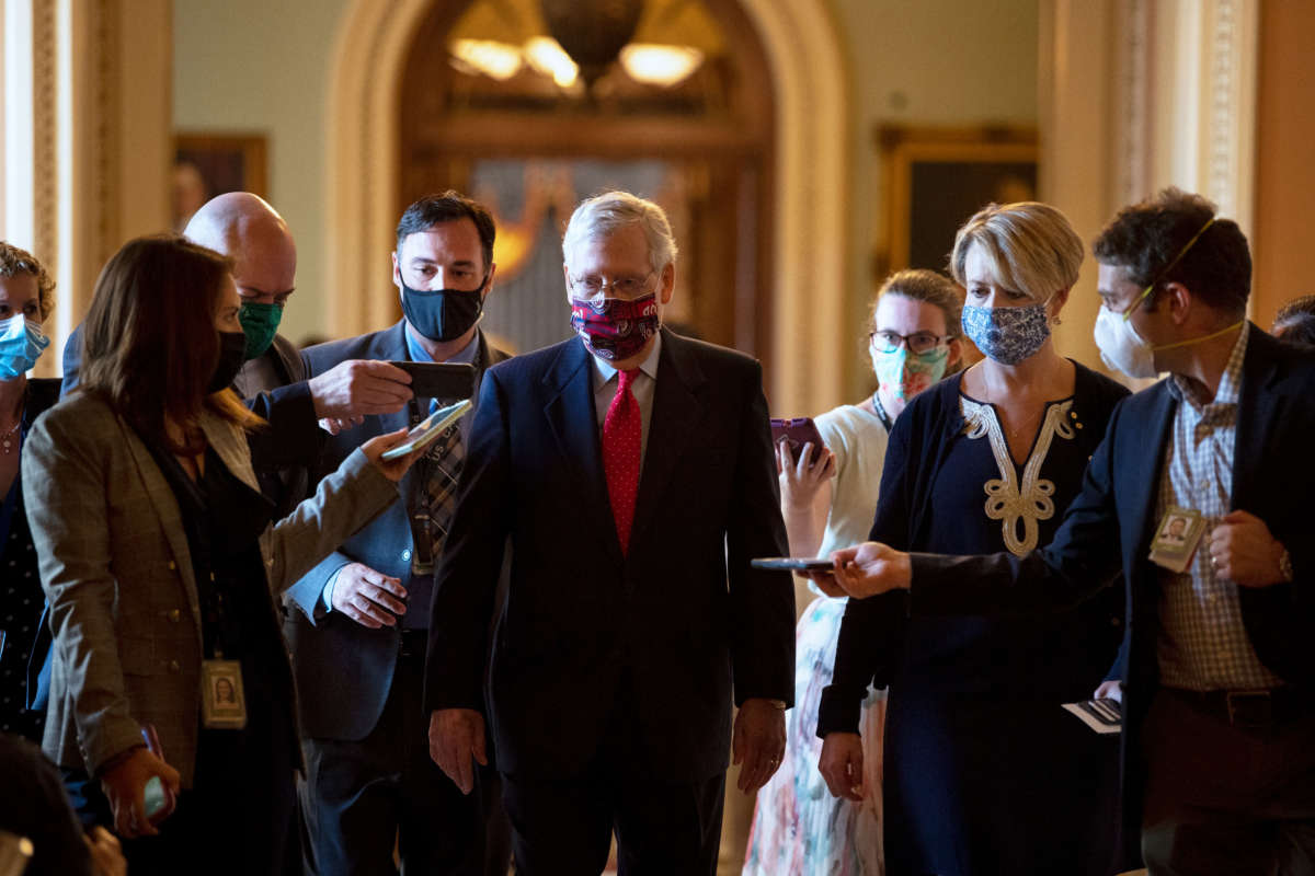 Senate Majority Leader Mitch McConnell talks with reporters as he walks from the Senate floor after a vote to his office on July 30, 2020.
