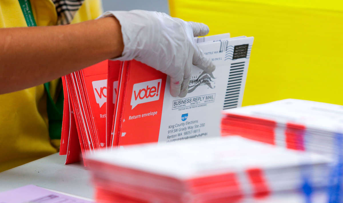 An election worker opens envelopes containing vote-by-mail ballots for the Washington state primary at King County Elections in Renton, Washington, on August 3, 2020.
