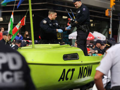 Police gather around a small sailboat that was dropped off in Times Square as part of a protest by the environmental group Extinction Rebellion on October 10, 2019, in New York City.