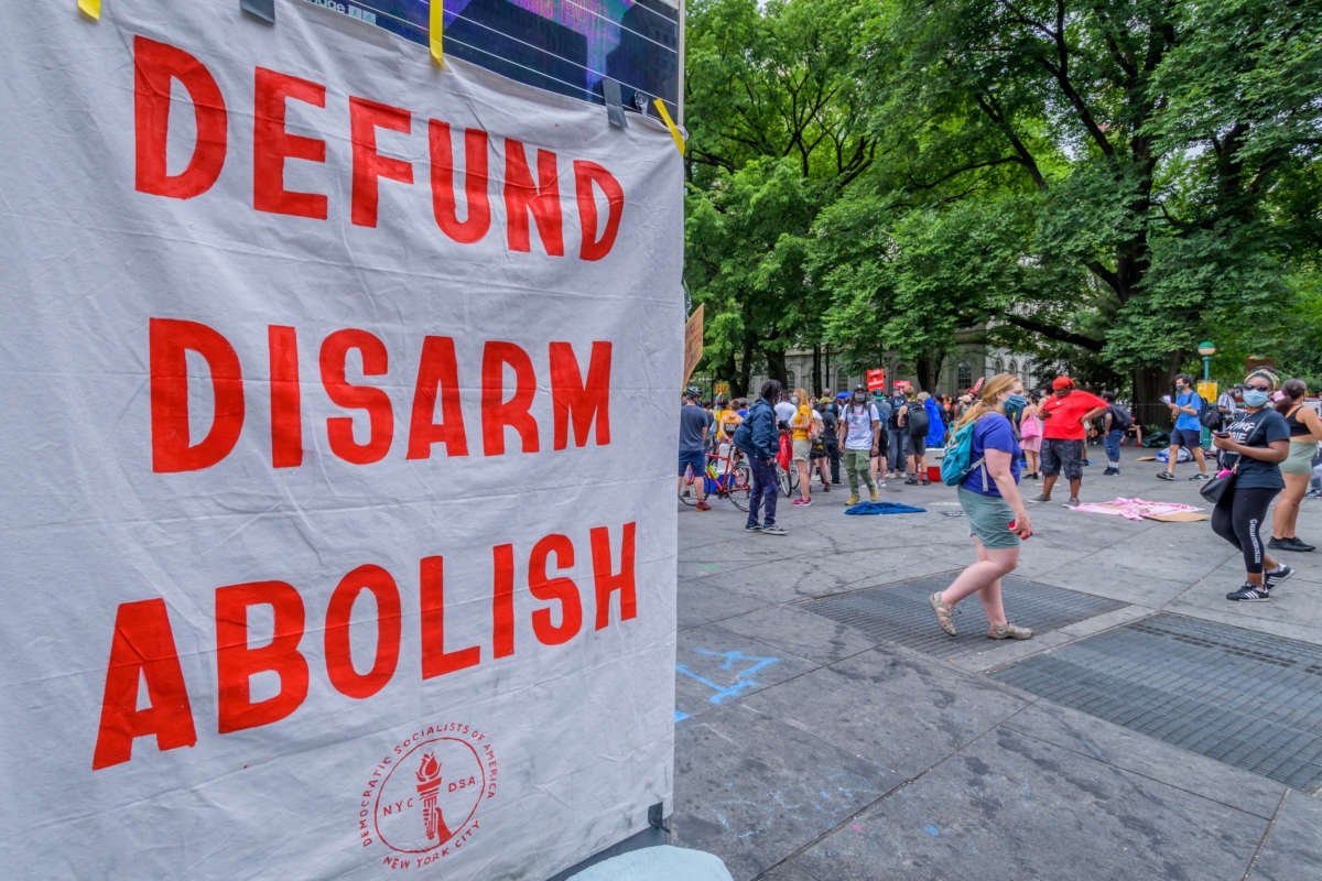 A banner with the text "Defund Disarm Abolish" hangs at the entrance of the Occupy City Hall encampment on June 27, 2020, in New York City.