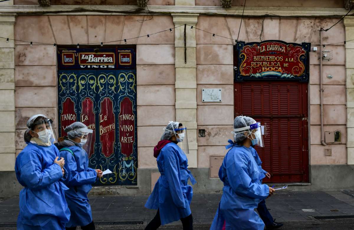 Health workers walk at Caminito street after visiting people suspected of having COVID-19 at La Boca neighbourhood in Buenos Aires, on July 9, 2020, amid the new coronavirus pandemic.