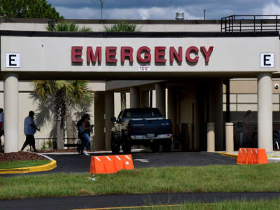 People are seen outside the entrance to the emergency room at Oak Hill Hospital in Hernando County, one of 23 counties in the state of Florida that has no available adult ICU beds.