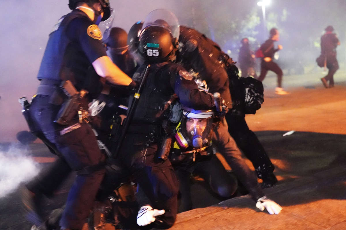 Four Portland police officers arrest a protester during a crowd dispersal near Mississippi Avenue on August 14, 2020, in Portland, Oregon.