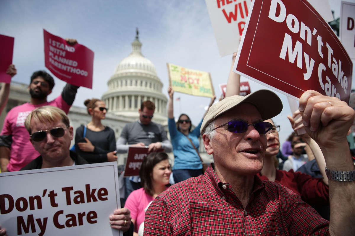 Activists hold signs during a health care rally on May 4, 2017, in front of the Capitol in Washington, D.C.