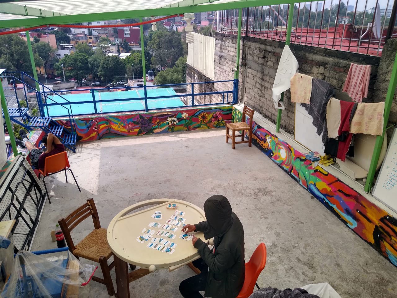 A migrant plays solitaire to pass the time during pandemic lockdown on the roof of Casa Tochan, Mexico City.