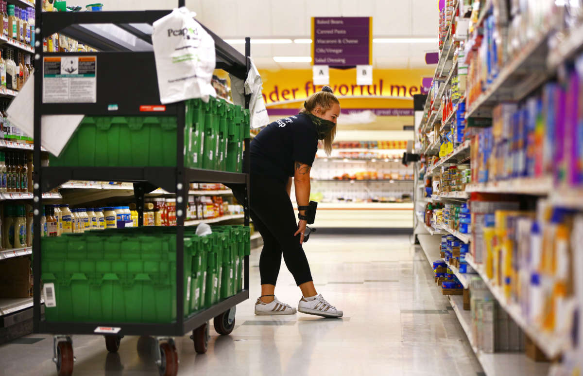 Clerk Ali Hutchings looks for an item to fulfill a grocery delivery order at Stop and Shop in Brockton, Massachusetts, on August 17, 2020.