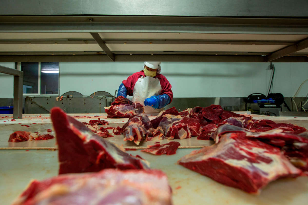 A butcher chops up beef at Jones Meat & Food Services in Rigby, Idaho, May 26, 2020.