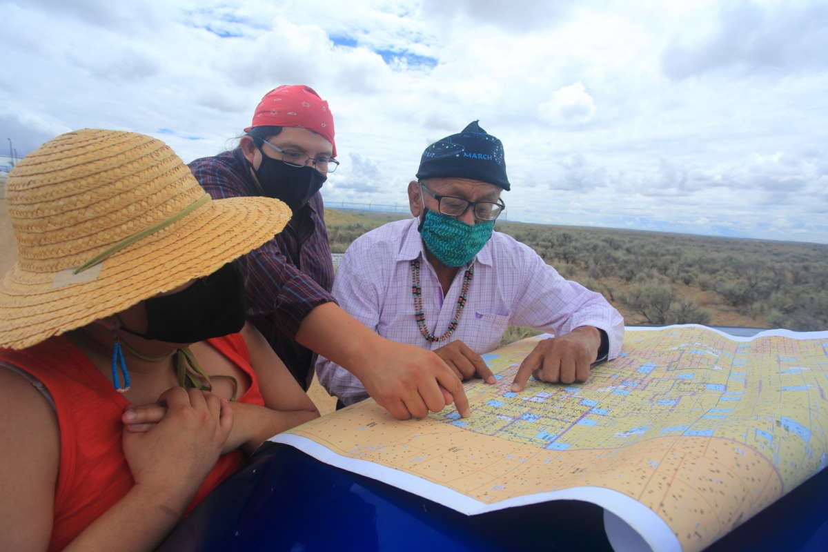 Navajo Tribal Council member Daniel Tso (also pictured on the previ- ous page) and Mario Atencio of Diné CARE (middle) study a map of oil leases in the Nation’s Eastern Agency. The BLM’s new guidelines will allow up to 3,000 more frack wells in the Greater Chaco region.