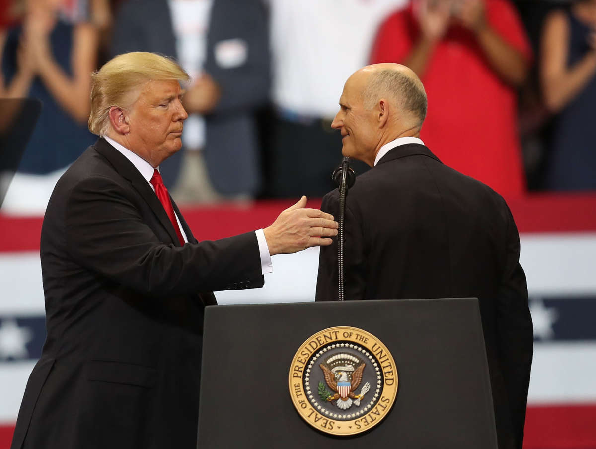 President Donald Trump stands with Sen. Rick Scott during a campaign rally at the Hertz Arena on October 31, 2018, in Estero, Florida.