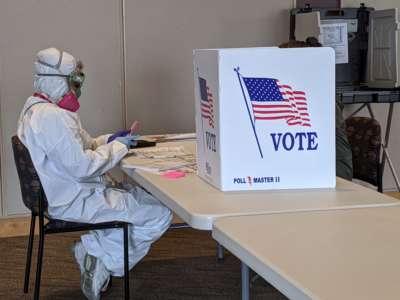 A person in a hazmat suit counts votes