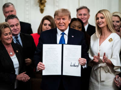 President Trump, with Ivanka Trump, signs an executive order after delivering remarks at the White House Summit on Human Trafficking in the East Room at the White House on January 31, 2020, in Washington, D.C.