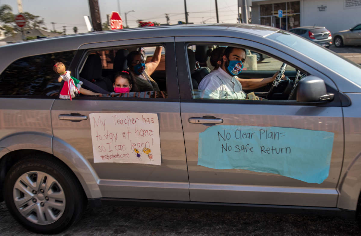 A young student with her family participates in a car caravan to protest against the Compton Unified School District for reopening schools despite what many teachers and community members say are unsafe conditions on October 1, 2020, in Compton, California.