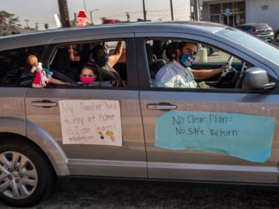 A young student with her family participates in a car caravan to protest against the Compton Unified School District for reopening schools despite what many teachers and community members say are unsafe conditions on October 1, 2020, in Compton, California.