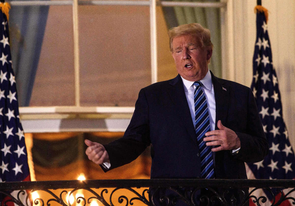 President Trump gestures from the Truman Balcony upon his return to the White House from Walter Reed Medical Center in Washington, D.C., on October 5, 2020.