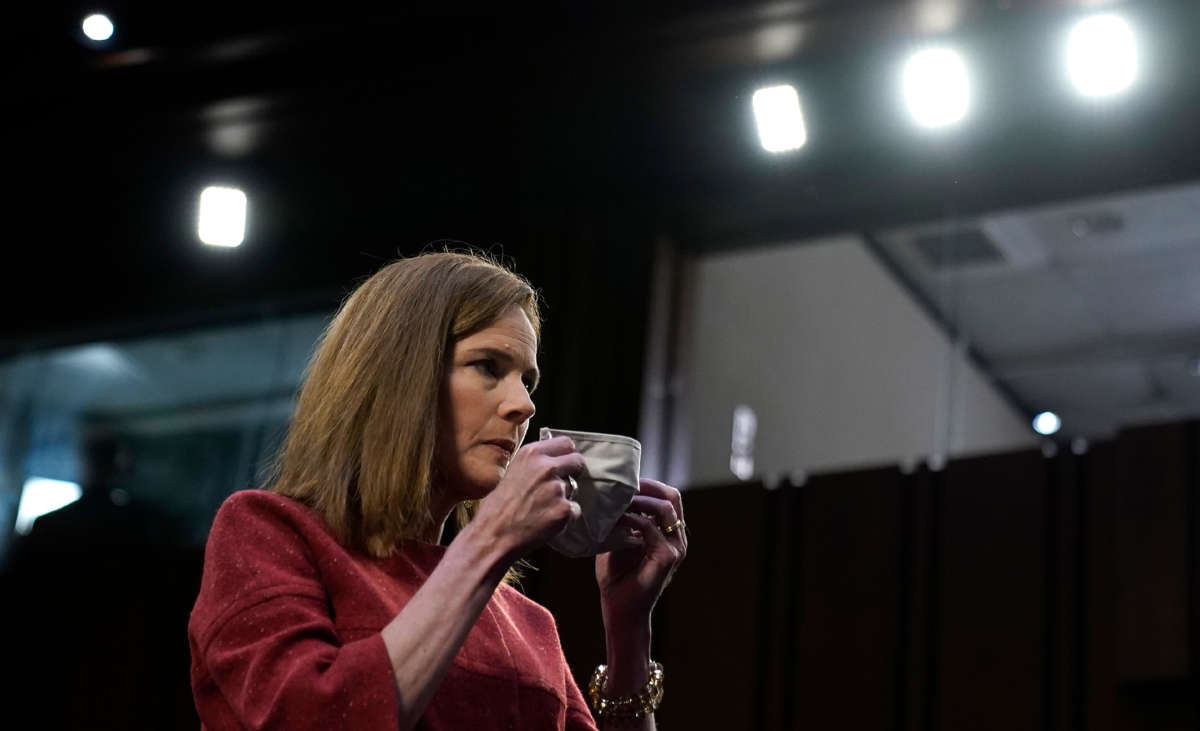 Supreme Court nominee Judge Amy Coney Barrett puts on her mask at start of recess break in the second day of her Senate Judiciary committee confirmation hearing on Capitol Hill on October 13, 2020, in Washington, D.C.
