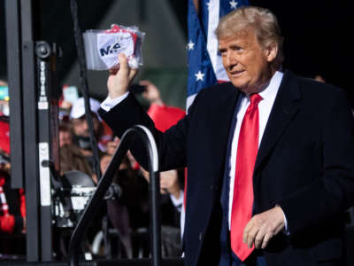 President Trump holds masks as he arrives for a rally at John Murtha Johnstown-Cambria County Airport in Johnstown, Pennsylvania, October 13, 2020.