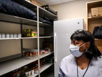 A medical worker looks at empty storage shelves in her hospital
