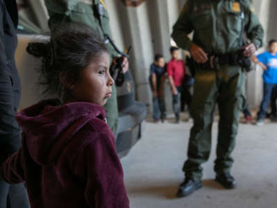 A girl from Ecuador waits to be transported with her mother to a U.S. Customs and Border Protection processing center on September 10, 2019, near Los Ebanos, Texas.