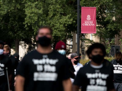 University of South Carolina football players walk to a team bus after participating in a demonstration on campus against racial inequality and police brutality on August 31, 2020, in Columbia, South Carolina.