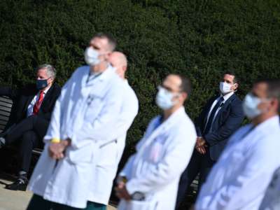 White House Chief of Staff Mark Meadows (left) listens as White House physician Sean Conley answers questions surrounded by other doctors, during an update on the condition of President Donald Trump, on October 4, 2020, at Walter Reed National Military Medical Center in Bethesda, Maryland.