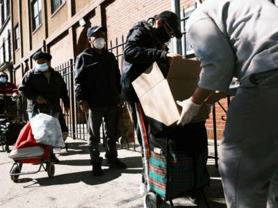 People receive food at the Thessalonica Christian Church during a distribution on October 17, 2020, in New York City.