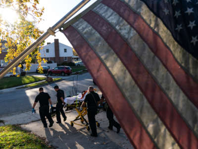 Paramedics and firefighters with Anne Arundel County Fire Department prepare to transport a patient to the hospital on November 10, 2020, in Glen Burnie, Maryland.