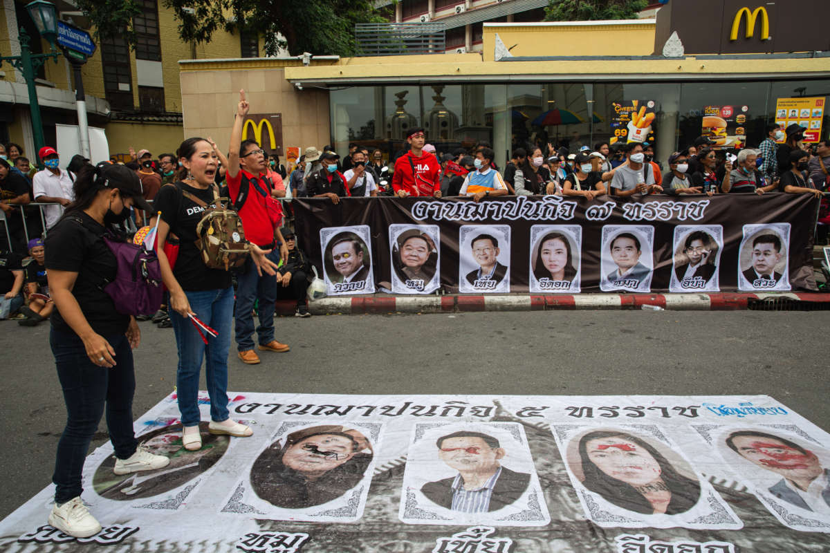 Protesters stamp their feet on posters with Junta government leaders and the government-sided politicians during a demonstration in Bangkok, Thailand.