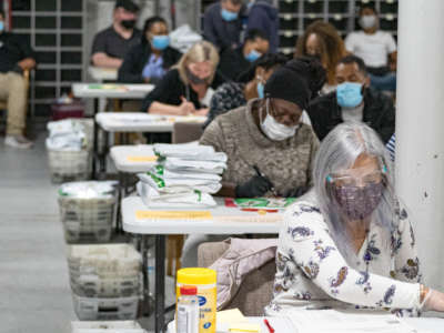 Gwinnett County election workers handle ballots as part of the recount for the 2020 presidential election at the Beauty P. Baldwin Voter Registrations and Elections Building on November 16, 2020, in Lawrenceville, Georgia.