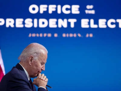 Joe Biden gazes thoughtfully past his folded hands
