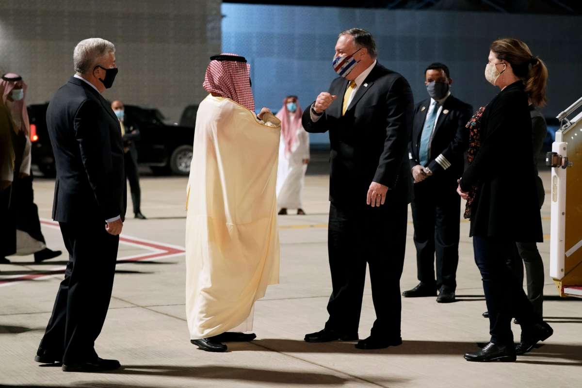 Mike Pompeo greets someone as he exits a plane
