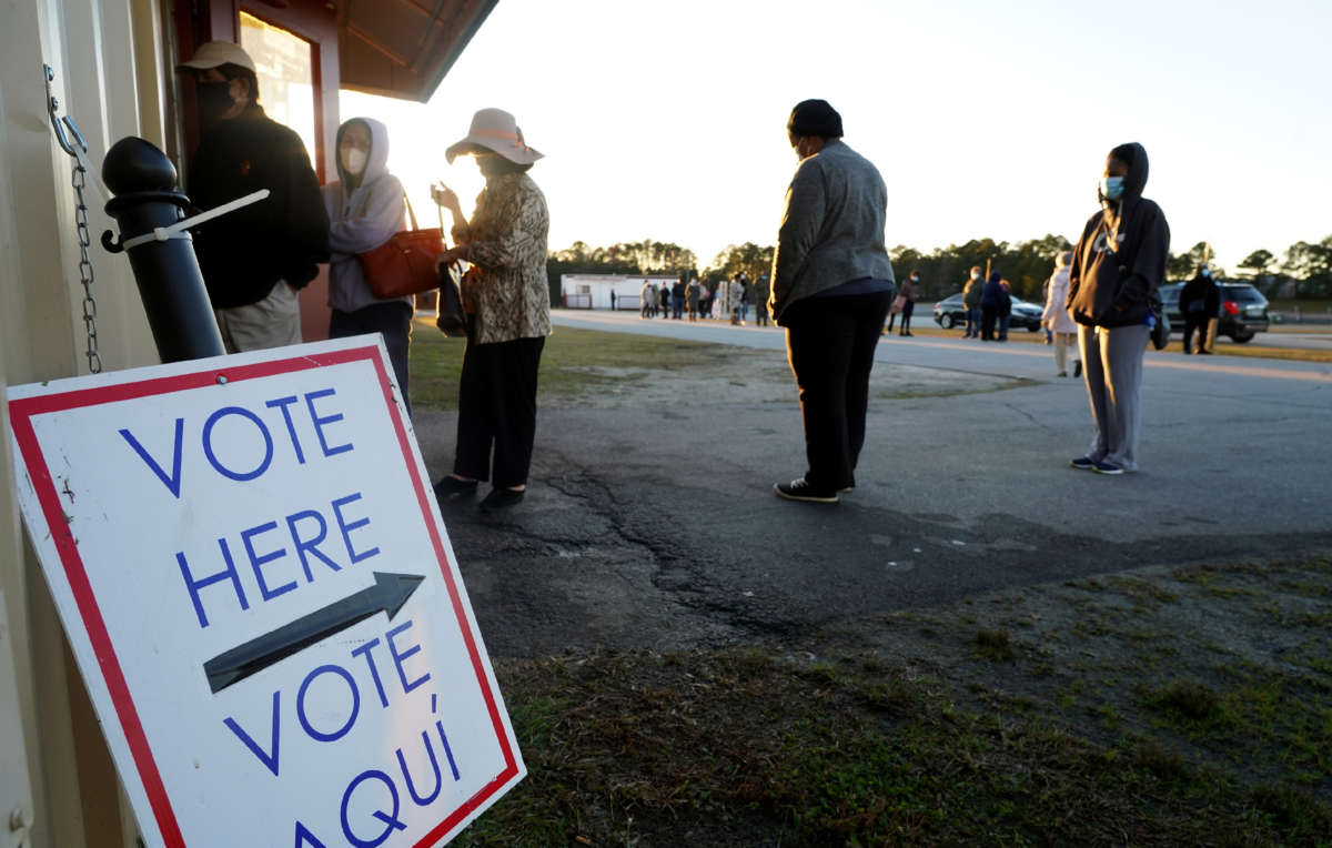 Voters stand in line to cast their ballots during the first day of early voting in the Senate runoff at the Gwinnett Fairgrounds, on December 14, 2020, in Atlanta, Georgia.