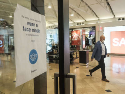 Signs urging social distancing and masks line the windows of most shops at the Franklin Park Mall during the Black Friday sales event on November 27, 2020, in Toledo, Ohio.