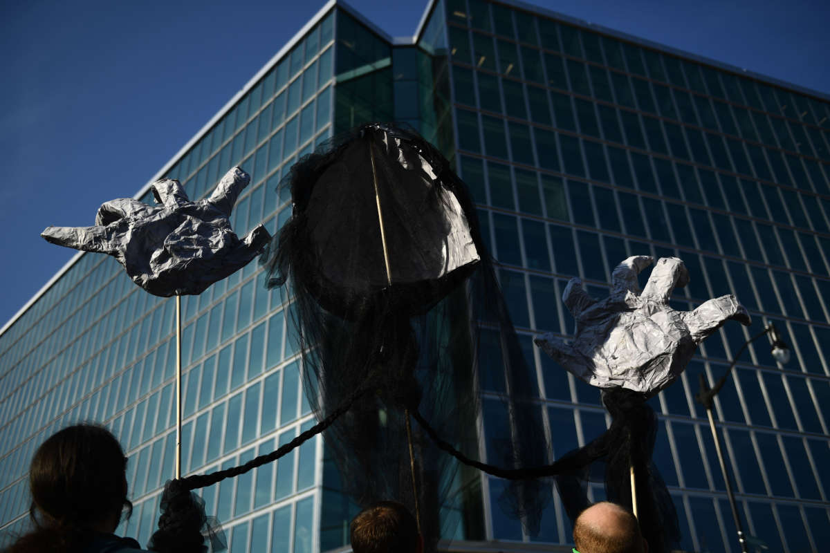 Environmental activists gather with puppet signs outside the American Petroleum Institute on September 23, 2019, in Washington, D.C.