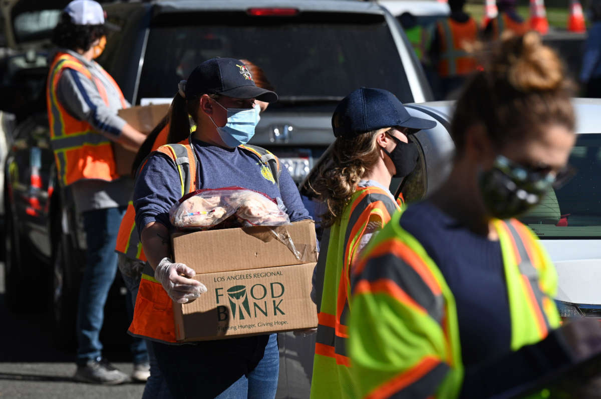 Volunteers load free groceries into cars for people experiencing food insecurity due to the coronavirus pandemic, December 1, 2020, in Los Angeles, California.