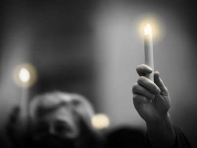 A person holds a candle during a candlelight vigil