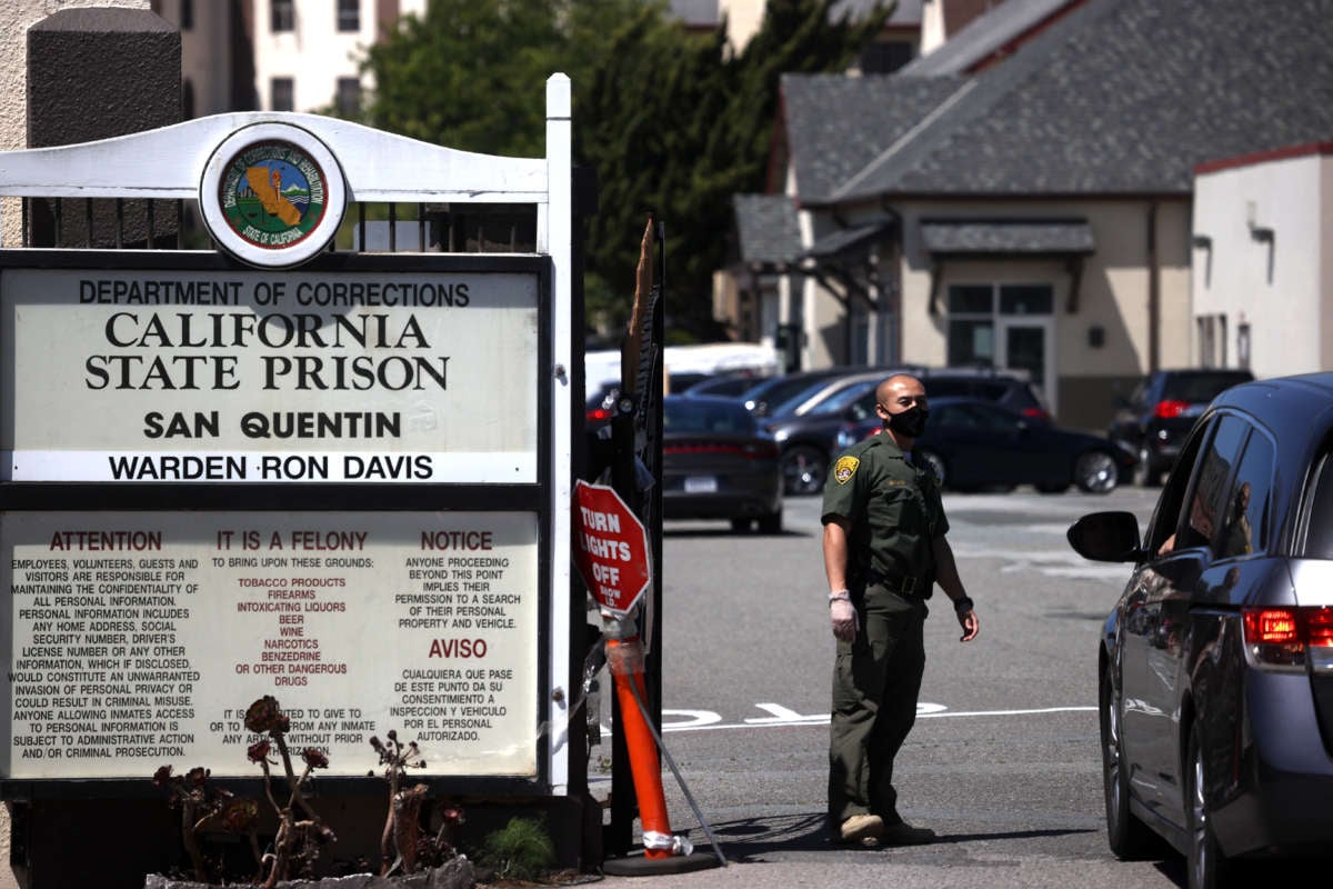 A California Department of Corrections and Rehabilitation (CDCR) officer wears a protective mask as he stands guard at the front gate of San Quentin State Prison on June 29, 2020, in San Quentin, California.
