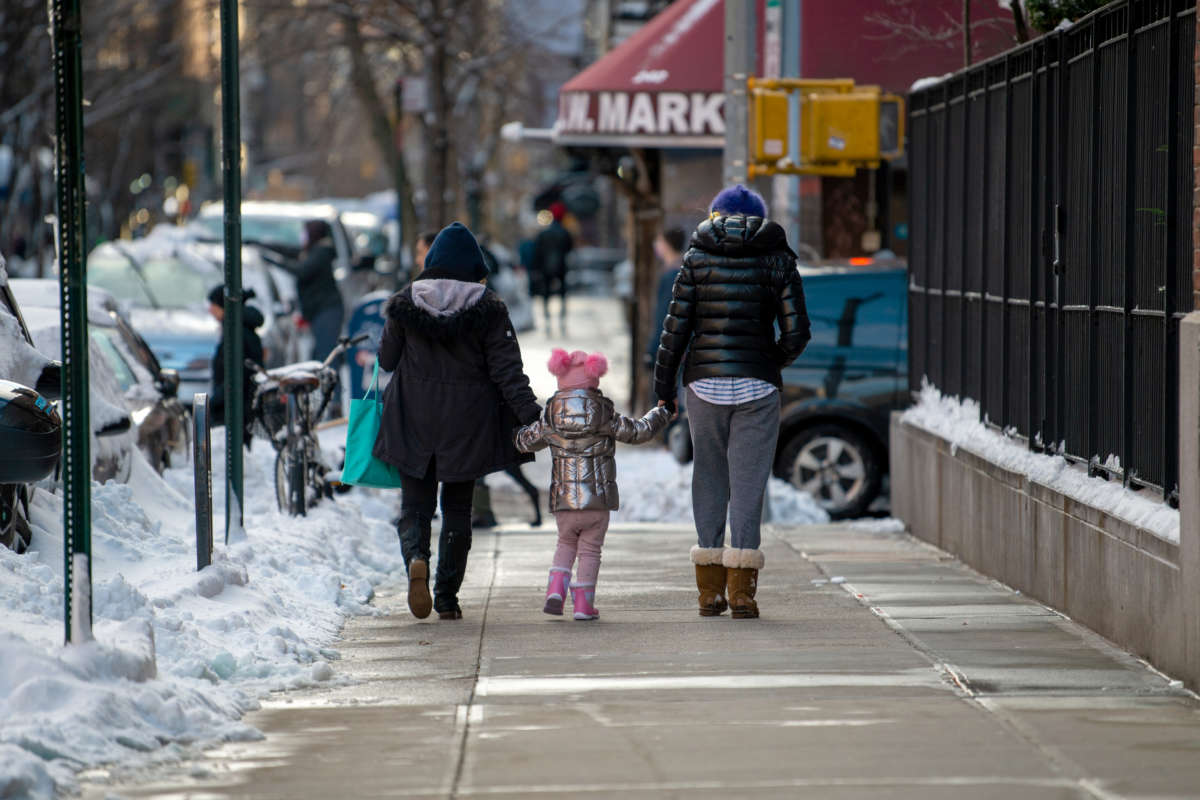 People walk with a child on December 17, 2020, in New York City.