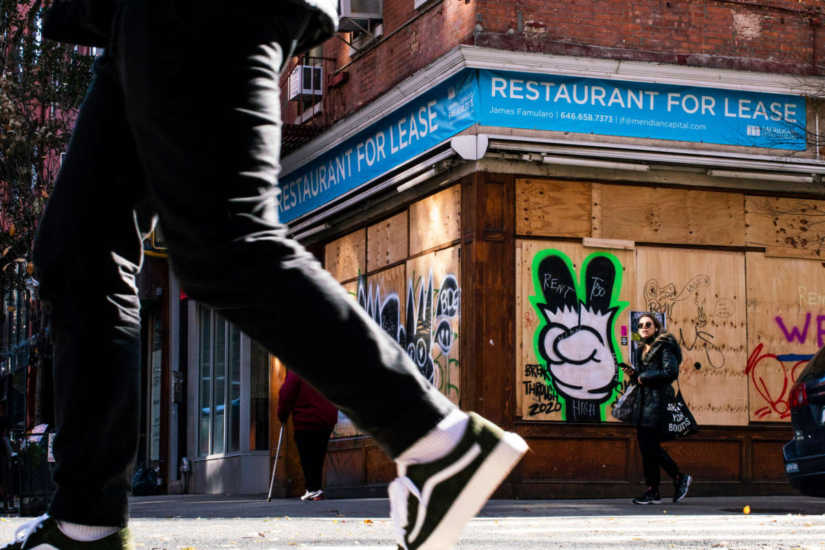 People walk near a restaurant closed by the pandemic as the global outbreak of COVID-19 continues on November 23, 2020, in New York.