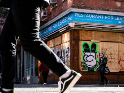 People walk near a restaurant closed by the pandemic as the global outbreak of COVID-19 continues on November 23, 2020, in New York.