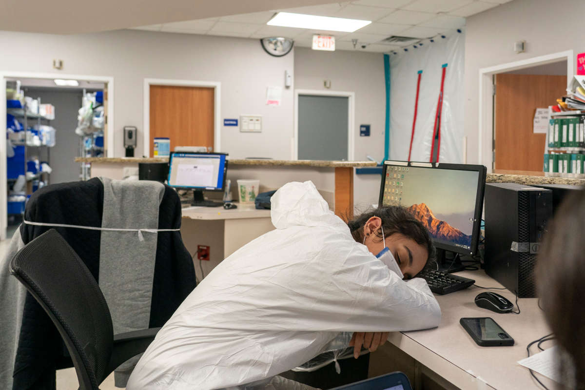 An exhausted medial worker sleeps at her desk