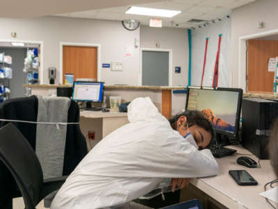 An exhausted medial worker sleeps at her desk