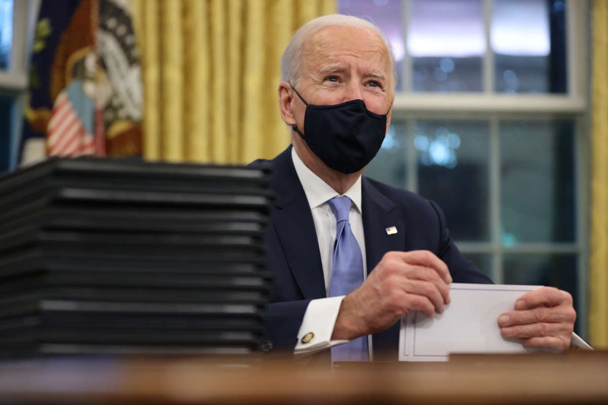President Joe Biden prepares to sign a series of executive orders at the Resolute Desk in the Oval Office just hours after his inauguration on January 20, 2021, in Washington, D.C.