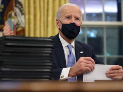 President Joe Biden prepares to sign a series of executive orders at the Resolute Desk in the Oval Office just hours after his inauguration on January 20, 2021, in Washington, D.C.