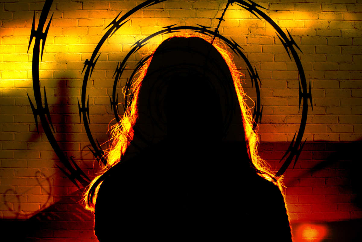 Silhouette of woman in front of razor wire