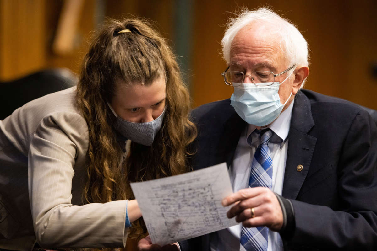 Sen. Bernie Sanders confers with a Congressional staff member during a hearing on Capitol Hill in Washington, D.C., on January 27, 2021.